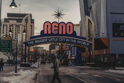 Man walking under neon sign in Reno