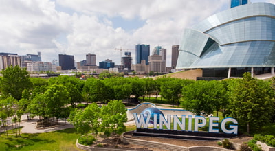 Green trees near Winnipeg city buildings