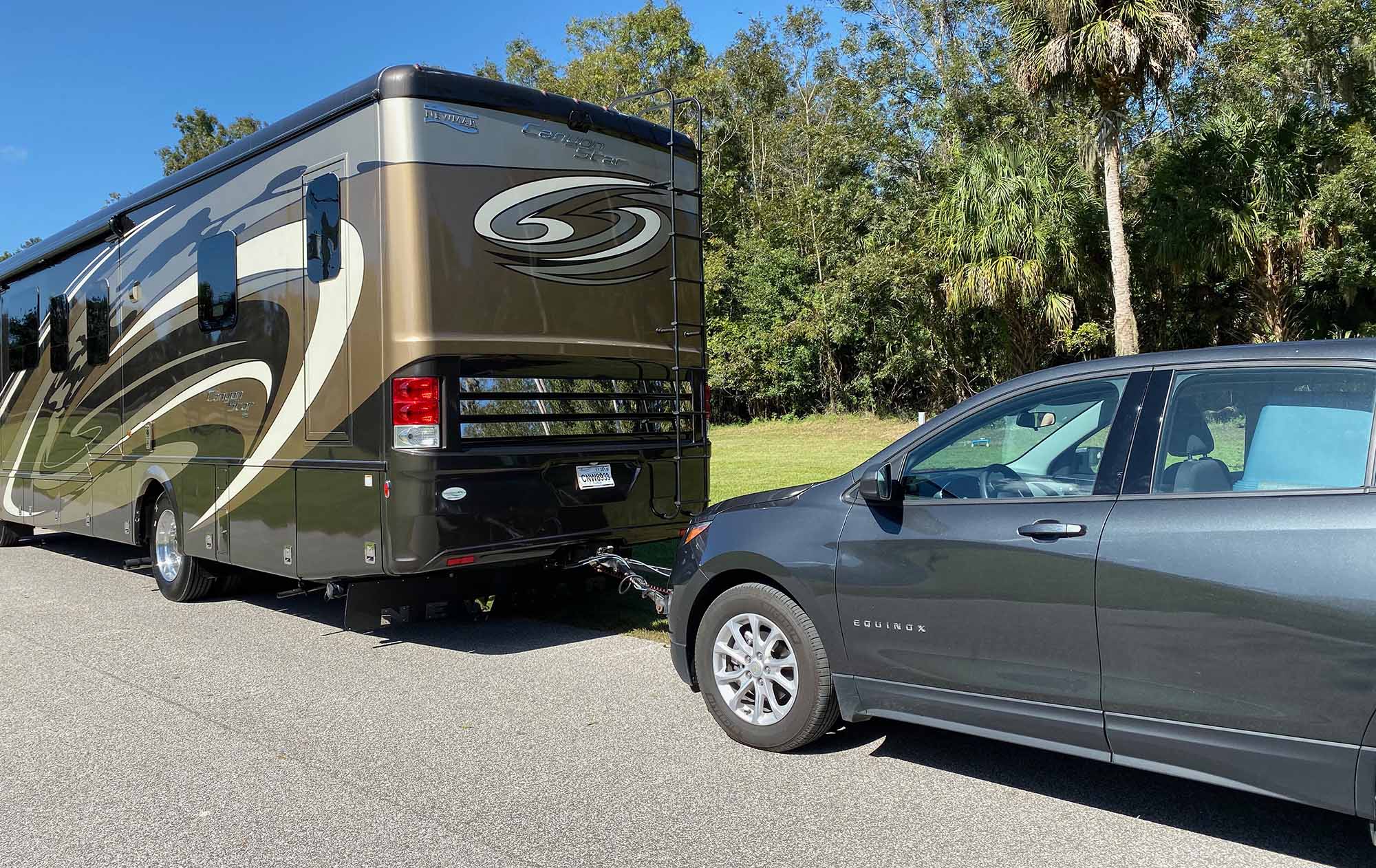 large new canyon star class a motorhome towing a Chevrolet equinox