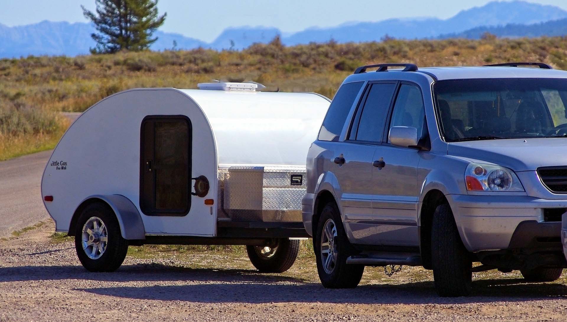 honda type vehicle towing a small tear-drop trailer.